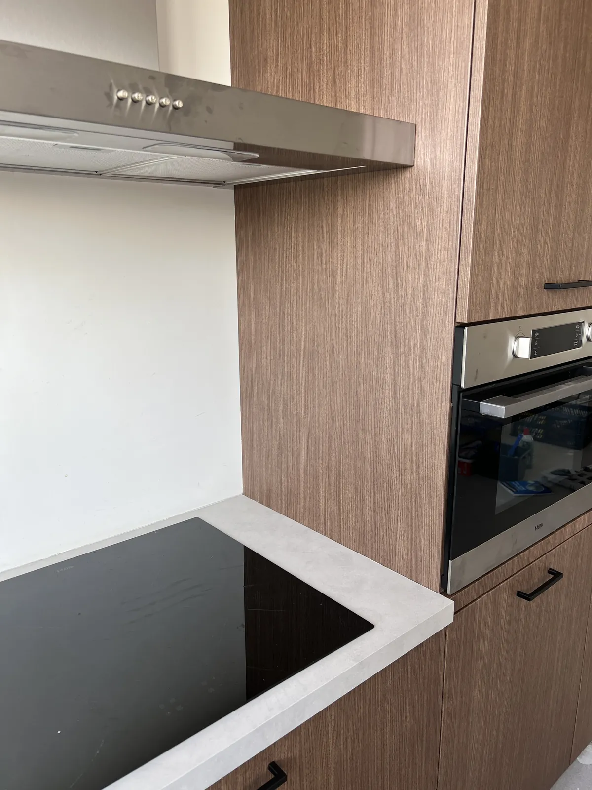 L-keuken met fronten in notenhoutlook folie en aanrechtblad in betonlook, foto 2