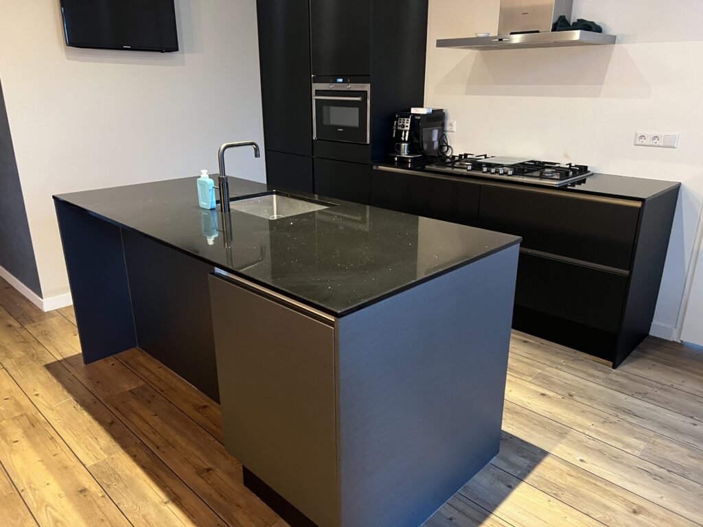 Keuken met matzwarte K1 achterwand en kookeiland in real metal grey folie